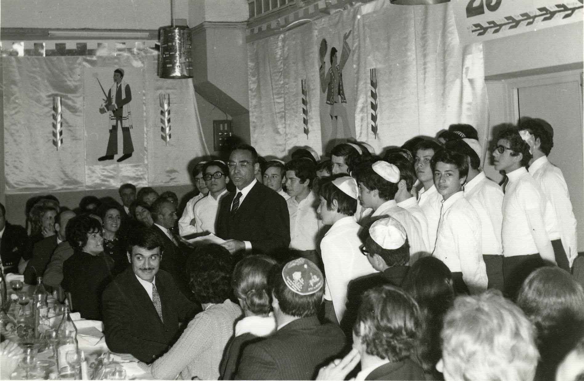 25ème anniversaire de l’Ecole Normale Hébraïque (ENH) de Casablanca.Dîner d’ouverture des parents d’élèves du dimanche 14 mars 1971 dans le réfectoire décoré de l’école .Allocution de M. E. Sebban, directeur de l’E.N.H.Derrière lui : la chrorale de l’école (Photo AIU)
